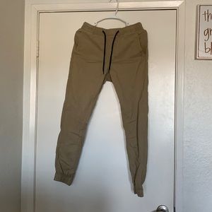 Tan denim pants with cinched ankles.